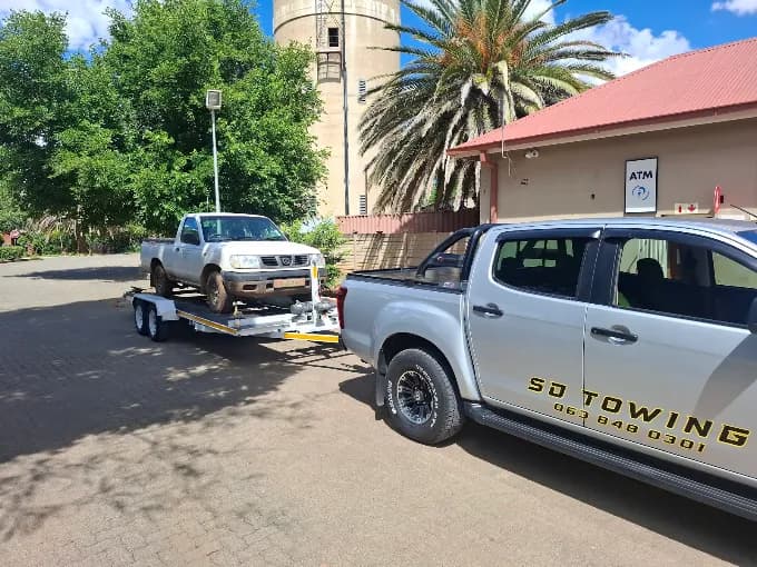 ASD Towing Isuzu towing a vehicle on a flatbed trailer