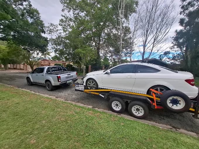 ASD Towing transporting a white Mercedes on a flatbed trailer in Bloemfontein